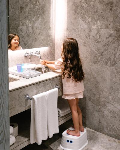 a little girl standing on a toilet in a bathroom at D - Resort Ayvalık in Ayvalık