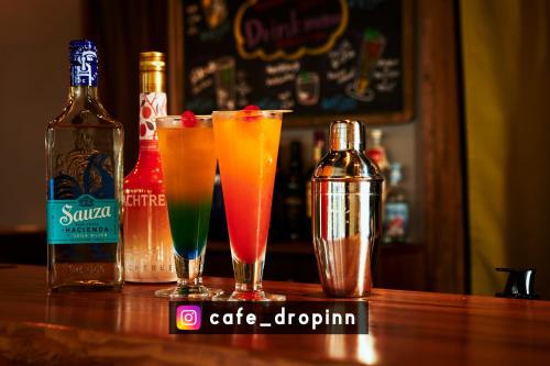 a group of drinks sitting on a bar with bottles at Drop Inn Tottori in Tottori