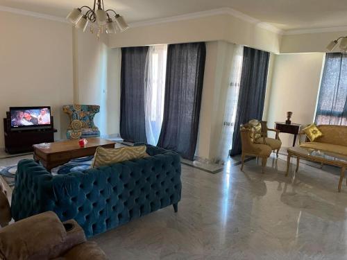 a living room with a blue couch and a tv at شقه فاخره - ابراج سان ستيفانو- جراند بلاز in Alexandria