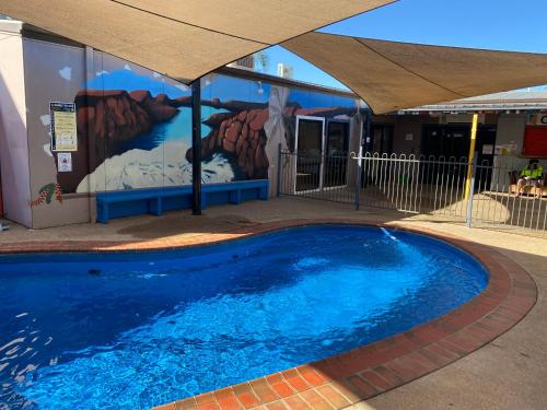 uma piscina em frente a um edifício com uma pintura em Sunraysia Stays em Mildura