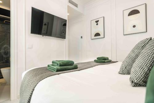 a bedroom with a bed with green towels on it at Deluxe Apartment - Historic Center by REMS in Málaga