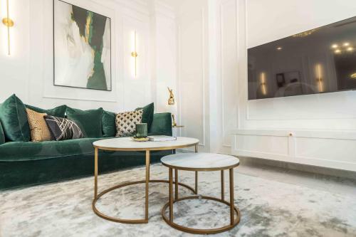 a living room with a green couch and a table at NEW Deluxe Apartment - Historic Center by REMS in Málaga
