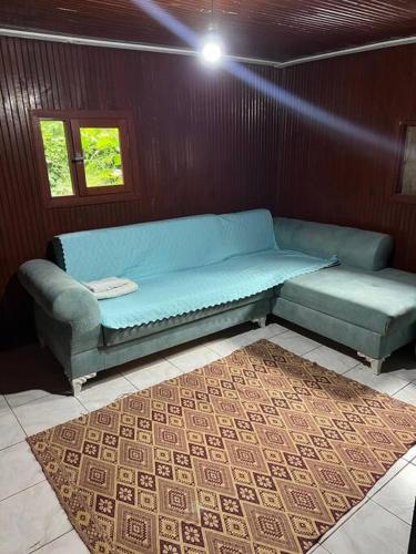 a blue couch sitting in a room with a rug at Havuzlu ahşap ev in Gemlik