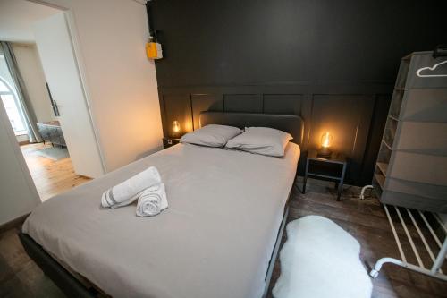 een slaapkamer met een groot bed met handdoeken erop bij LA FABRIQUE - Centre ville - Climatisation in Saint-Étienne