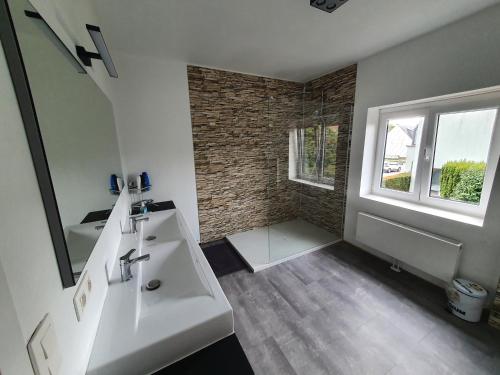 a bathroom with a white sink and a window at Private Room with shared spaces in Ranst