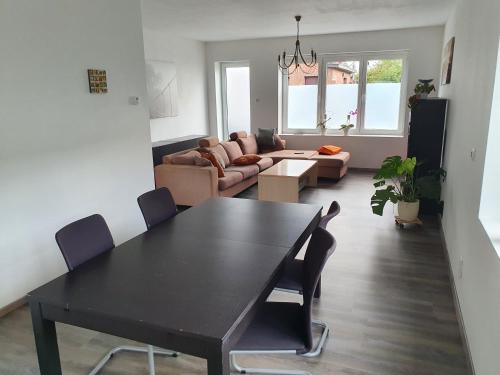 a living room with a black table and chairs at Private Room with shared spaces in Ranst