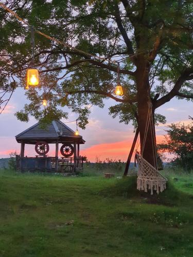 a tree and a gazebo with a bench under a tree at Nika in Nova Varoš