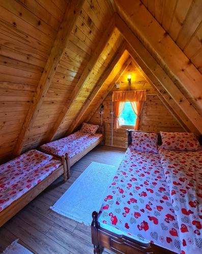 a bedroom with two beds in a wooden attic at Nika in Nova Varoš