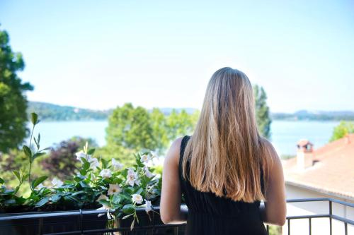 a woman looking out of a window at the water at Hotel Ristorante Vecchia Riva in Varese