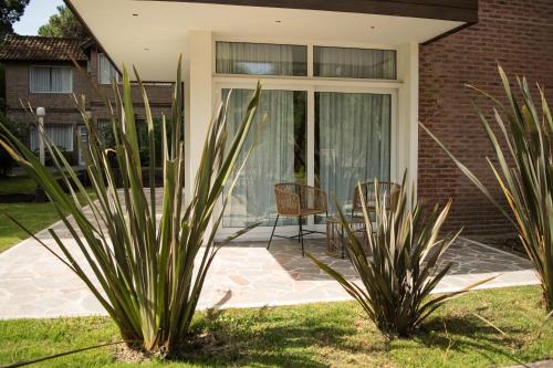 a patio with two plants in front of a house at Carilo Village Apart Hotel & Spa in Carilo