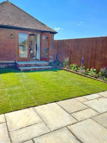 a yard with a house and a fence at Barons Granary , The Bull Pen in Iden