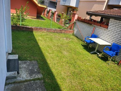a yard with two blue chairs and a table at Garsonjera u centru Prnjavor in Prnjavor