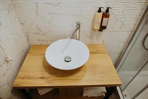 a white sink on a wooden table in a bathroom at Hotel Epic Centrum in Cisnădie
