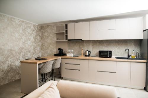a kitchen with white cabinets and a counter at Hotel Epic Centrum in Cisnădie