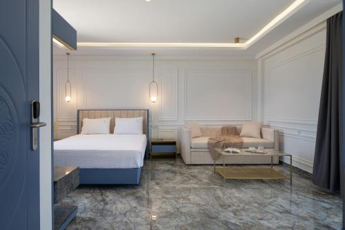 una camera d'albergo con letto e divano di ACROPOL GOLDEN SUITES a Néos Marmarás