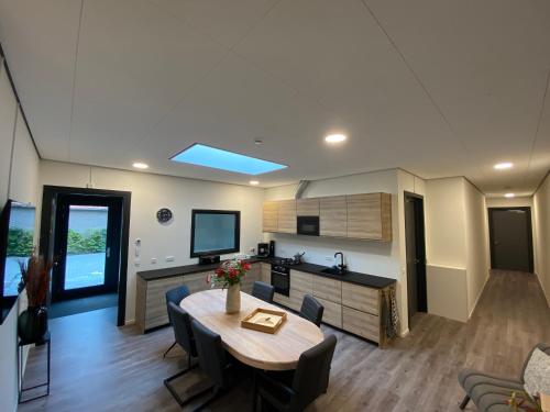 une cuisine et un salon avec une table et des chaises dans l'établissement Gasthuis Sanitatem, à Putten