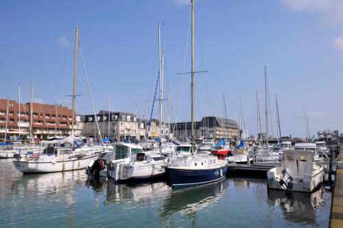 a bunch of boats are docked in a harbor at Le petit Courseulles - entre le port et la mer in Courseulles-sur-Mer
