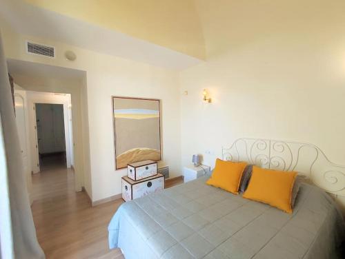 - une chambre avec un lit doté de deux oreillers orange et d'un miroir dans l'établissement Penthouse in Puerto Marina Benalmádena, à Benalmádena