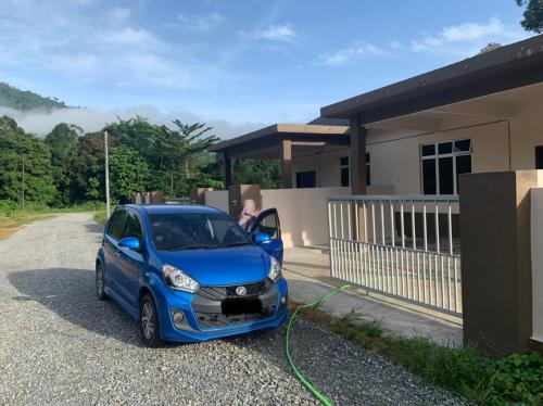 mały niebieski samochód zaparkowany przed domem w obiekcie Homestay Jeli - Cattleya Inn Muslim w mieście Jeli