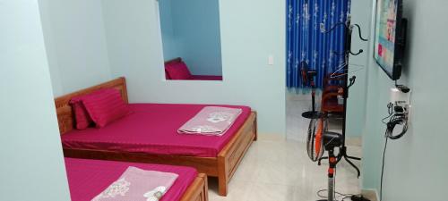 Habitación pequeña con cama y TV. en Nhà Nghỉ Tấn Phúc en Dồng Văn