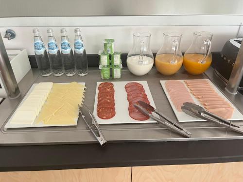 a kitchen counter with meat and cheese and other ingredients at Rupestre Arts Hotel Ródão in Vila Velha de Ródão
