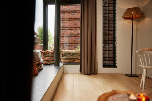 a living room with large windows and a table and chair at Business Guesthouse in Groningen