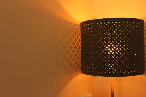 a black lamp with a shadow on a wall at Rito Hall da Serra in Leiria
