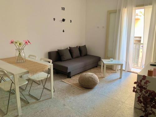 een woonkamer met een bank en een tafel bij Casa vacanza La Cuphea in Marina di Ragusa