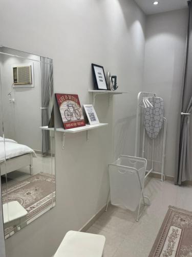 Zimmer mit Regalen, einem Bett und einem Stuhl in der Unterkunft Al Aseel Apartment Buyoot Al Diyafah in Ta'if