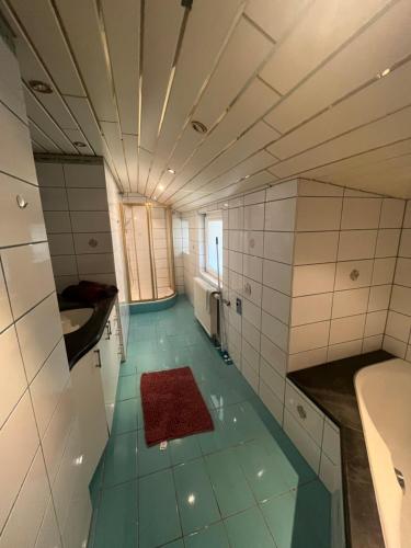 łazienka z niebieską podłogą i białymi kafelkami w obiekcie Santa Lucia Apartment Afritz w mieście Gassen