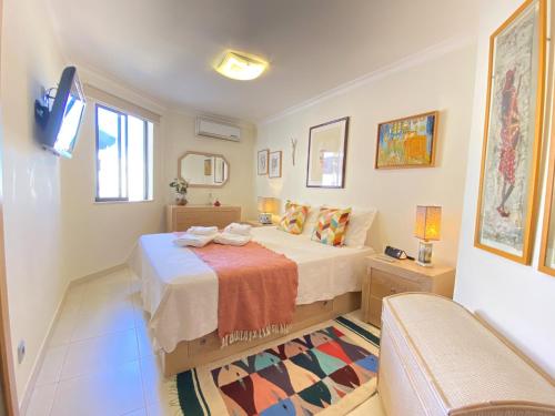 a bedroom with a bed and a tv and a couch at Vilamoura Central 7 With Pool by Homing in Vilamoura
