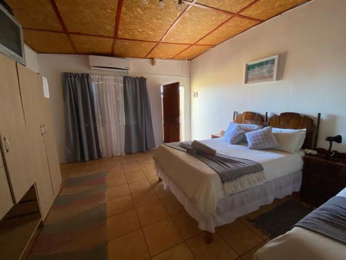 ein Schlafzimmer mit einem großen Bett in einem Zimmer in der Unterkunft El-Kole Bed and Breakfast in Tsumeb