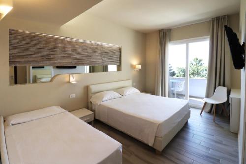 a hotel room with two beds and a window at Borgo San Cosmo Tropea in Brattirò
