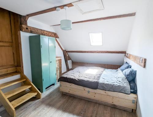 une petite chambre avec un lit et un escalier dans l'établissement LES REPAIRES, à Nans-sous-Sainte-Anne