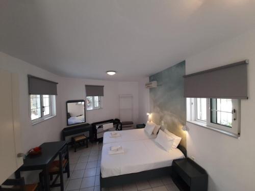 a hotel room with a bed and a desk and a room at Cost Mari Almyrida New by ZAGO Boutiqe hotels in Almirida