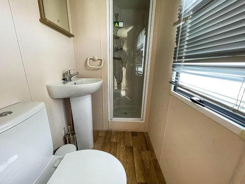 a small bathroom with a toilet and a sink at Lovely 8 Berth Caravan With Decking At Eastgate Fantasy Island Park Ref 58004c in Skegness