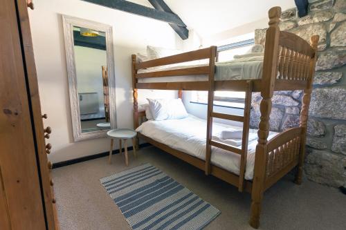 a bedroom with a bunk bed and a mirror at Idyllic Cornish cottage in the beautiful Lamorna valley - walk to pub & sea in Paul
