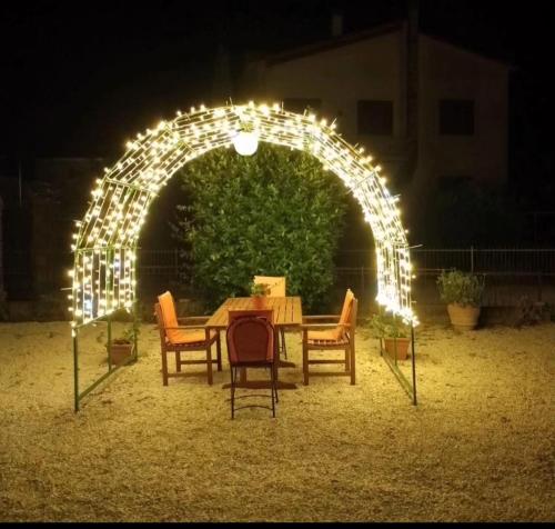 einen Tisch und Stühle unter einem Bogen mit Licht in der Unterkunft Villa Mezzetti in Petrignano sul Lago