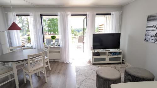 Rämsbyns Fritidsby في Rämshyttan: غرفة معيشة بيضاء مع طاولة وتلفزيون
