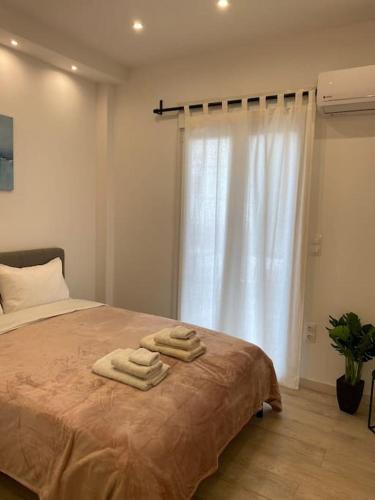 una camera da letto con un letto con tre asciugamani di Elysian - AT067 ad Atene