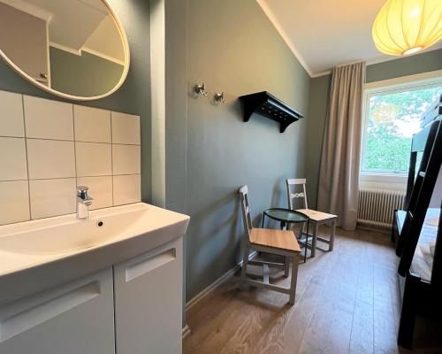 uma casa de banho com um lavatório, uma mesa e um espelho. em Vandrarhem Funäsdalen em Funäsdalen