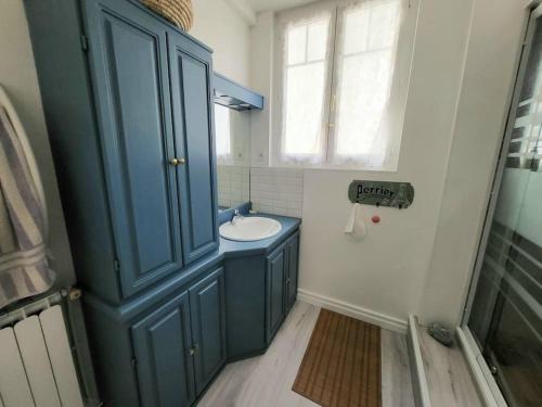 La salle de bains est pourvue d'une armoire bleue et d'un lavabo. dans l'établissement Appart au calme 3 chambres 73m2 1er étage, à Bayonne