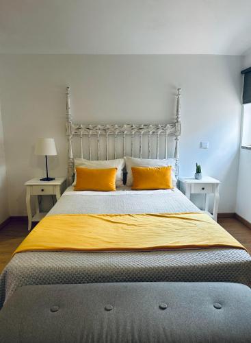a bedroom with a large bed with yellow pillows at Guest house D. Filipe I in Porto
