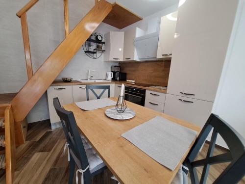 a small kitchen with a wooden table and chairs at Vila Kamicić in Baška