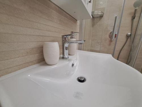 a bathroom with a white sink and a shower at Vila Kamicić in Baška