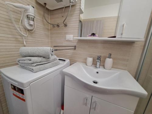 a small bathroom with a sink and a mirror at Vila Kamicić in Baška