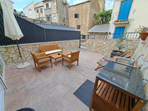a patio with chairs and a table and a fence at Vila Kamicić in Baška