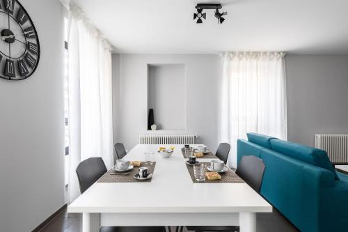 a dining room with a white table and blue chairs at Maraini Apartments by Quokka 360 - strategic location near Lugano station in Lugano