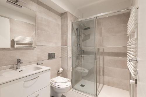 a bathroom with a shower and a toilet and a sink at Maraini Apartments by Quokka 360 - strategic location near Lugano station in Lugano