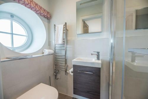 a bathroom with a toilet and a sink and a window at Quay View in Woodbridge